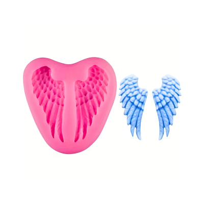 Pink heart-shaped silicone mold with carved angel wings beside a separate blue wing mold.